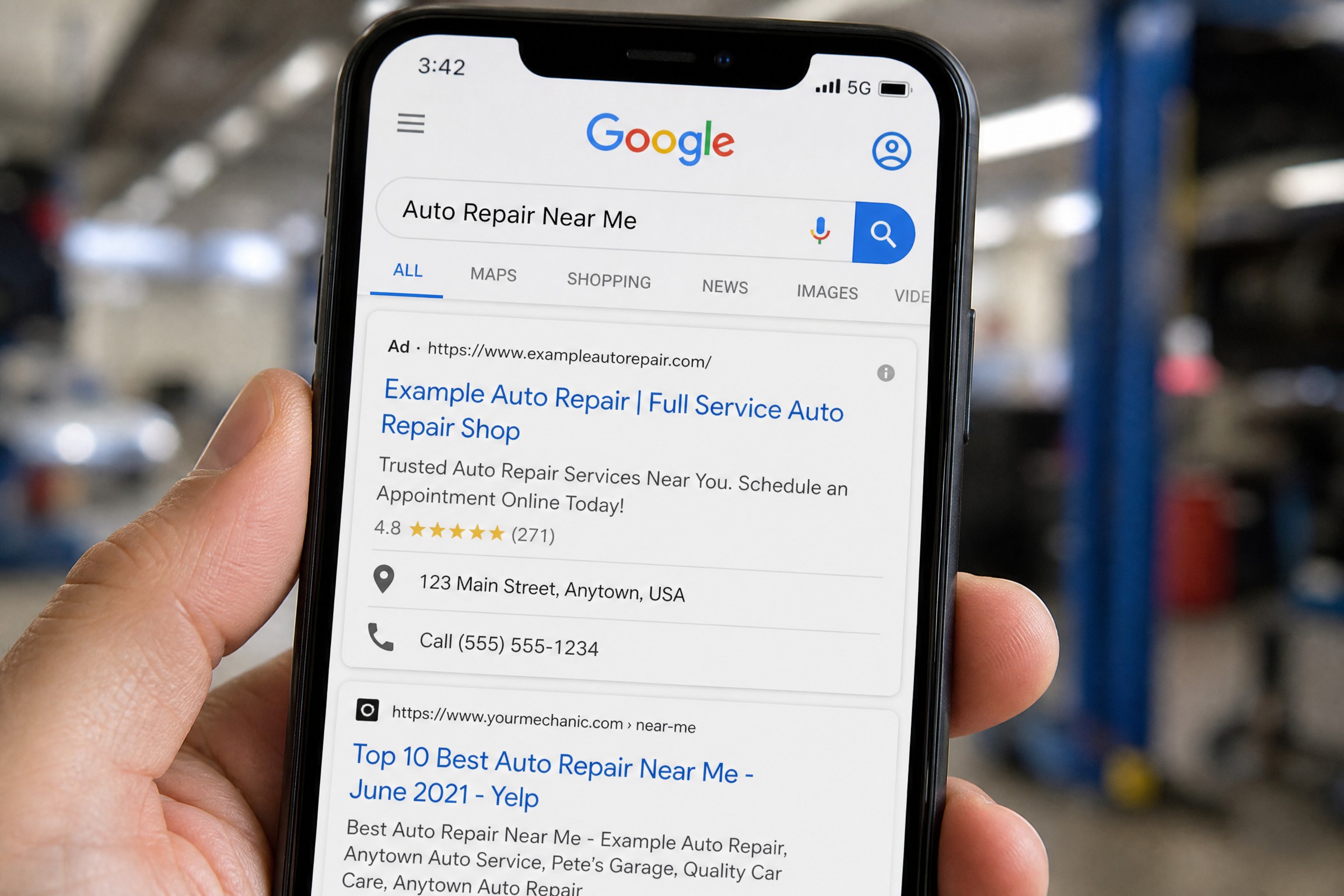 Smartphone showing Google search results with auto repair shop ad at the top