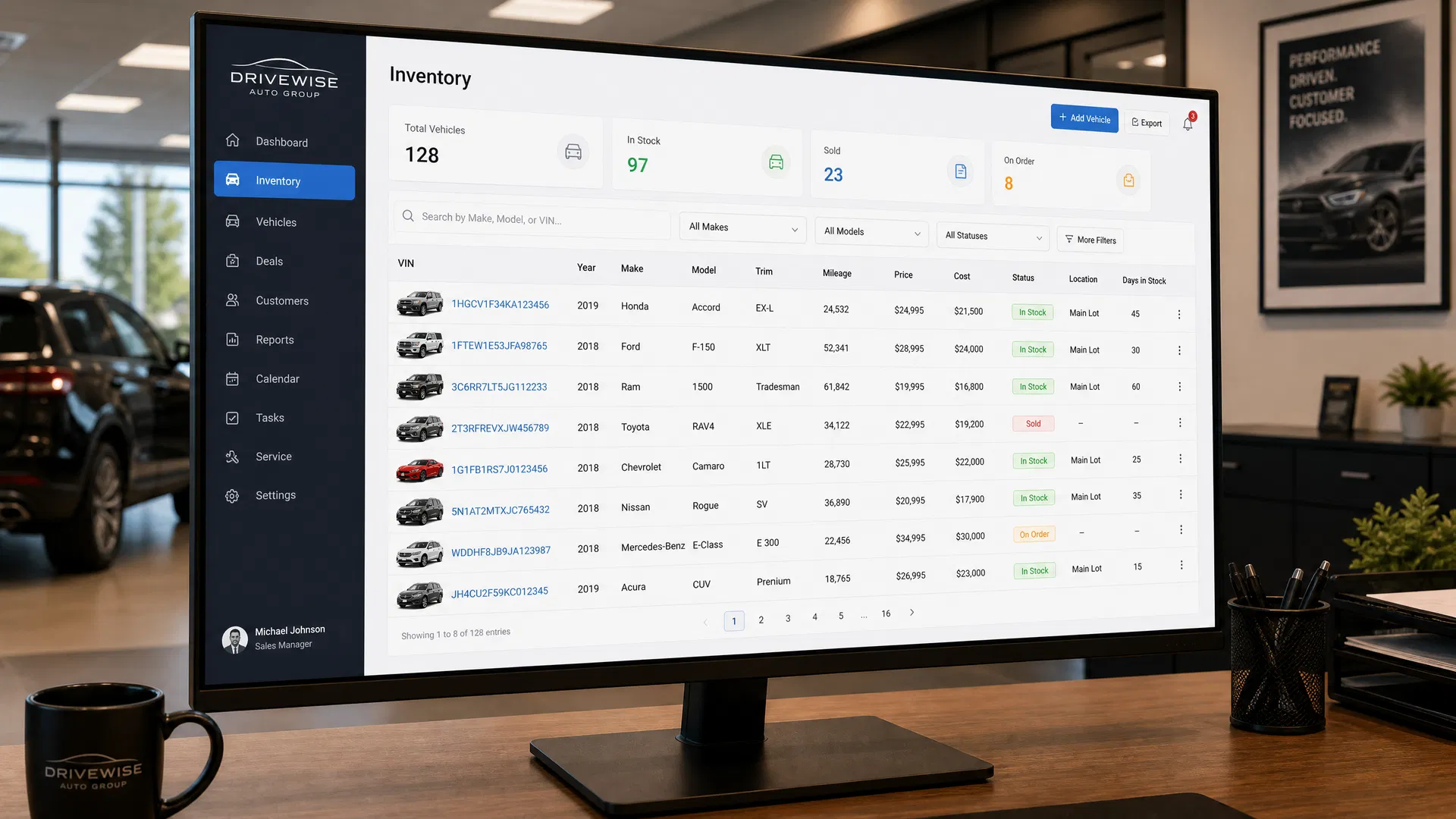 Dealer inventory management dashboard on a large monitor showing vehicle listings with VIN numbers, pricing, and stock status