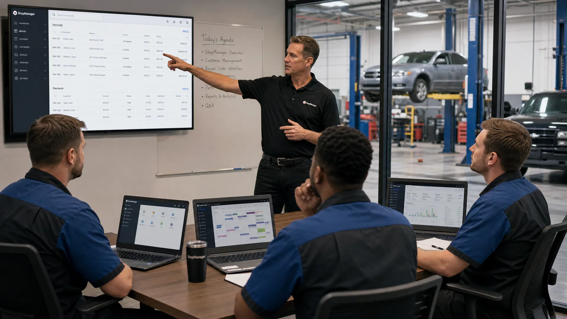Team training session with technicians learning the new garage management system on laptops